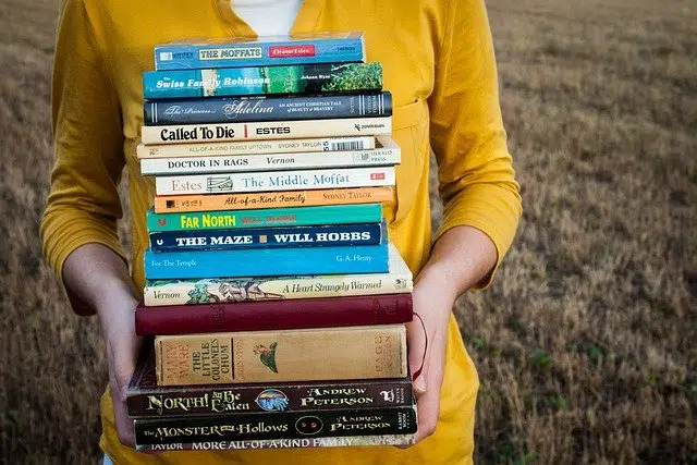 Woman holding stack of books