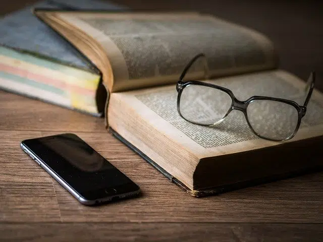 Books, glasses and a cell phone.