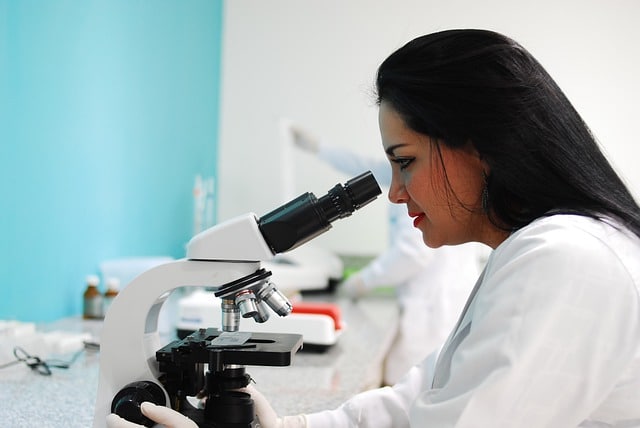 Female scientist using a microscope