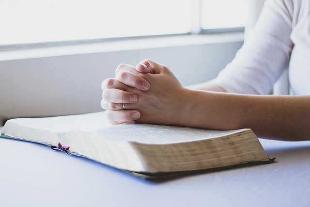 Person praying over the Bible