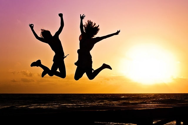 Two people jumping on the beach