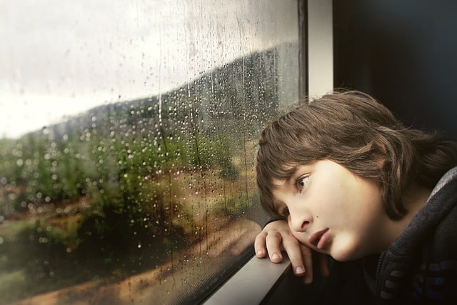 Boy looking out the window at the rain