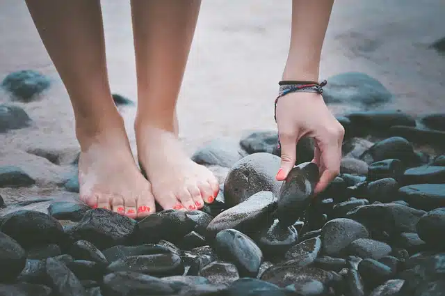 Woman picking up stone from the sea