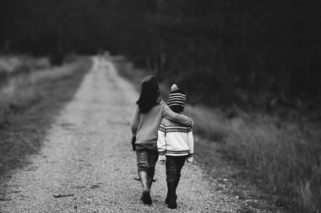 Two children walking hugging