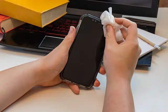 Person cleaning screen with wet cloth