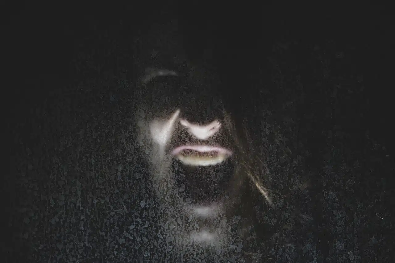 Young man screaming in the dark