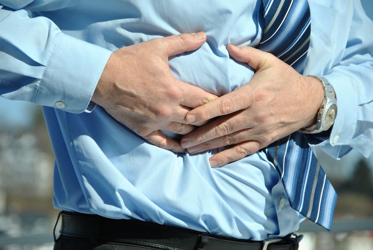 Man touching his abdomen in pain.