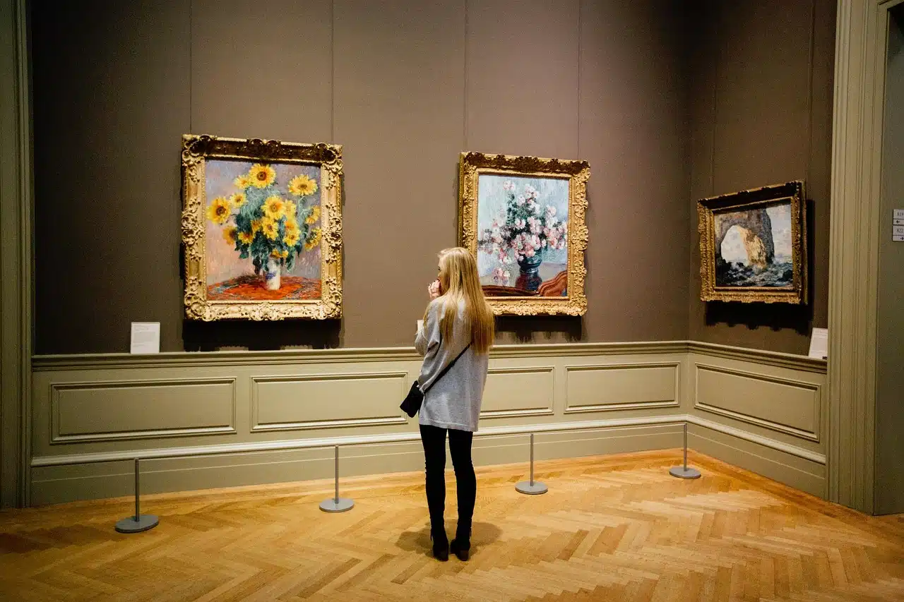 Woman looking at flower paintings in a museum