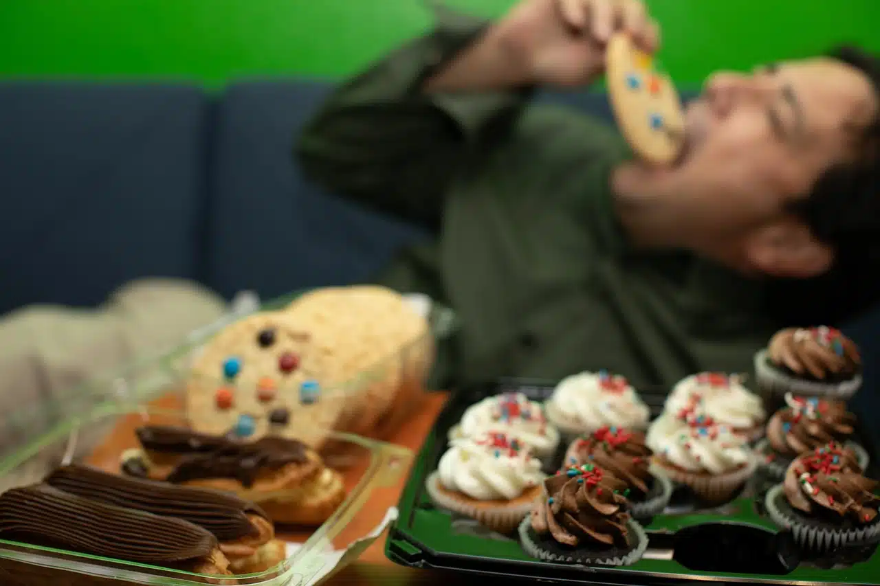 Gluttonous man eating sweets