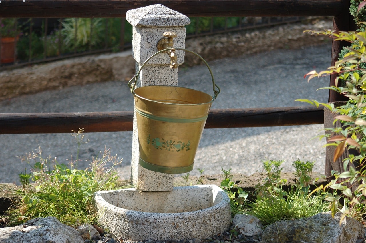 metal bucket hanging over a faucet