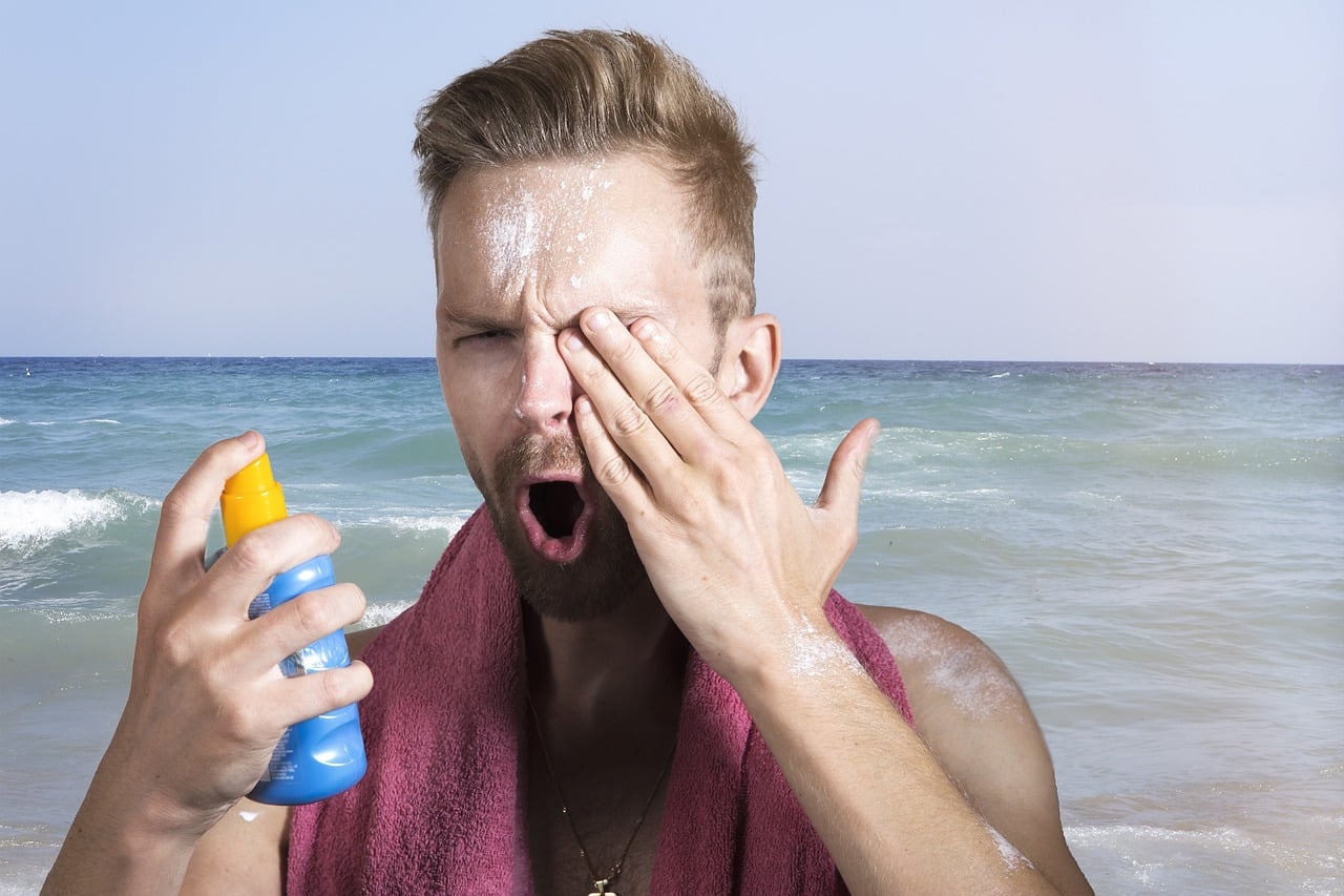 Man applying lotion on the beach