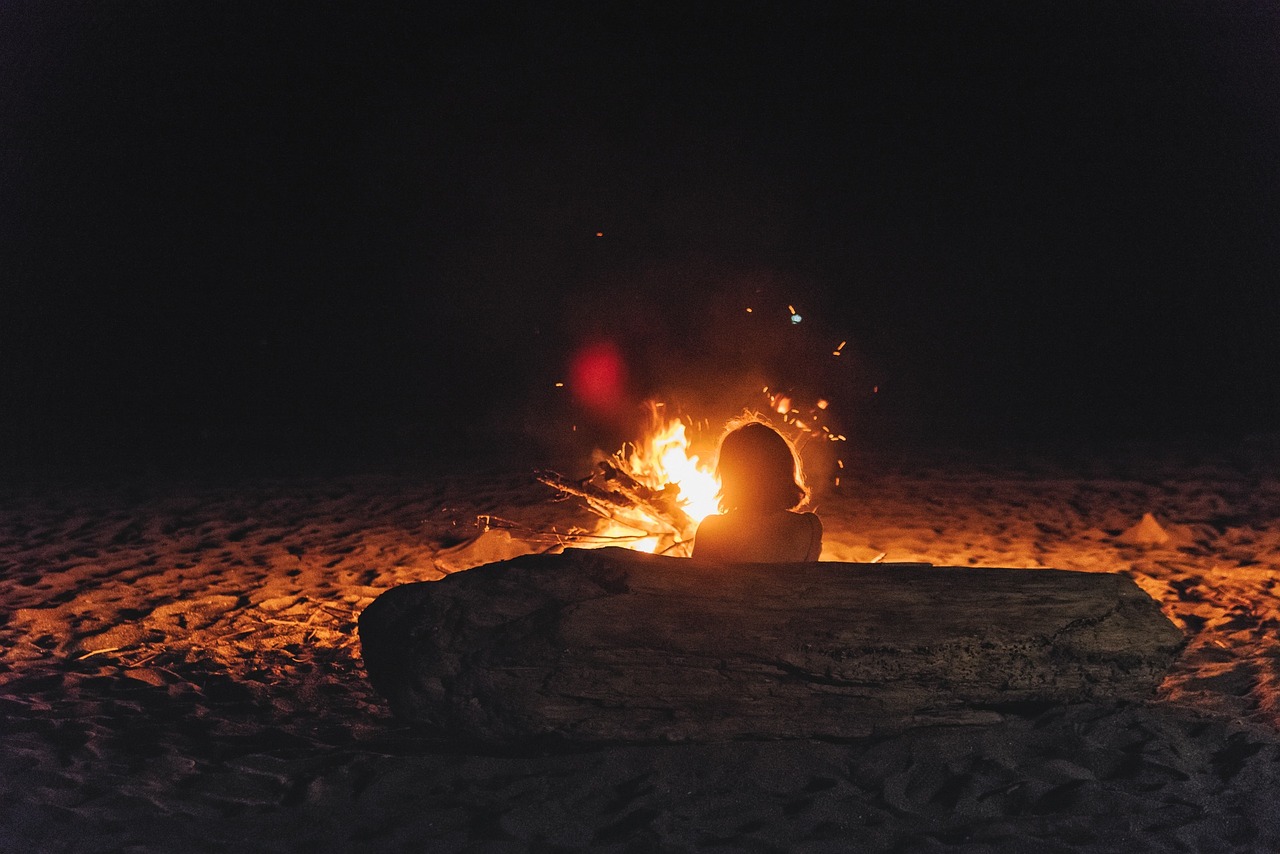 Woman sitting in front of a campfire