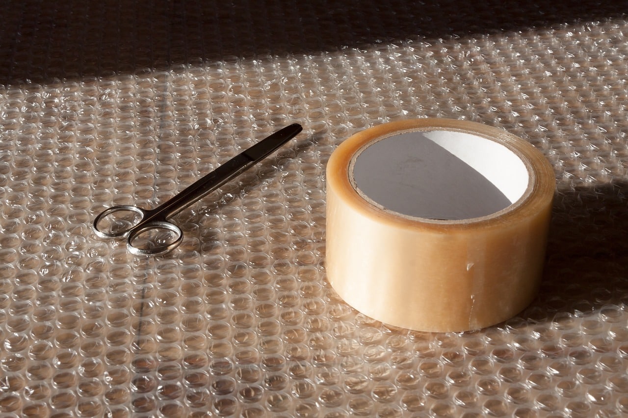 Roll of self-adhesive tape and scissors