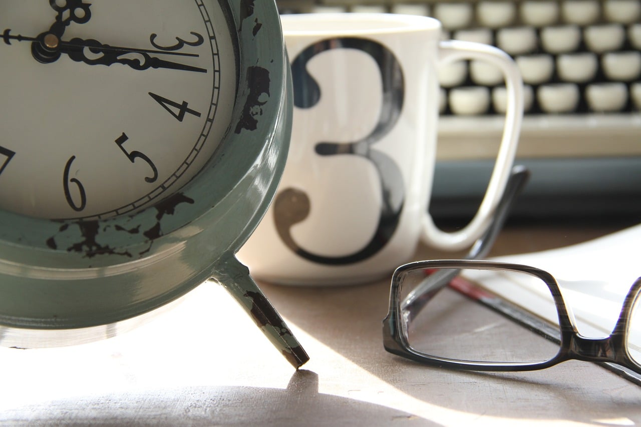 Alarm clock, cup, computer and glasses