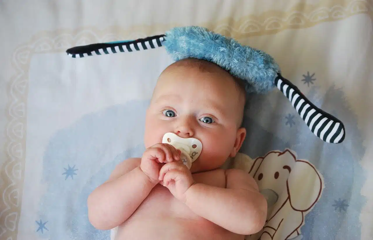 Baby with pacifier in his crib