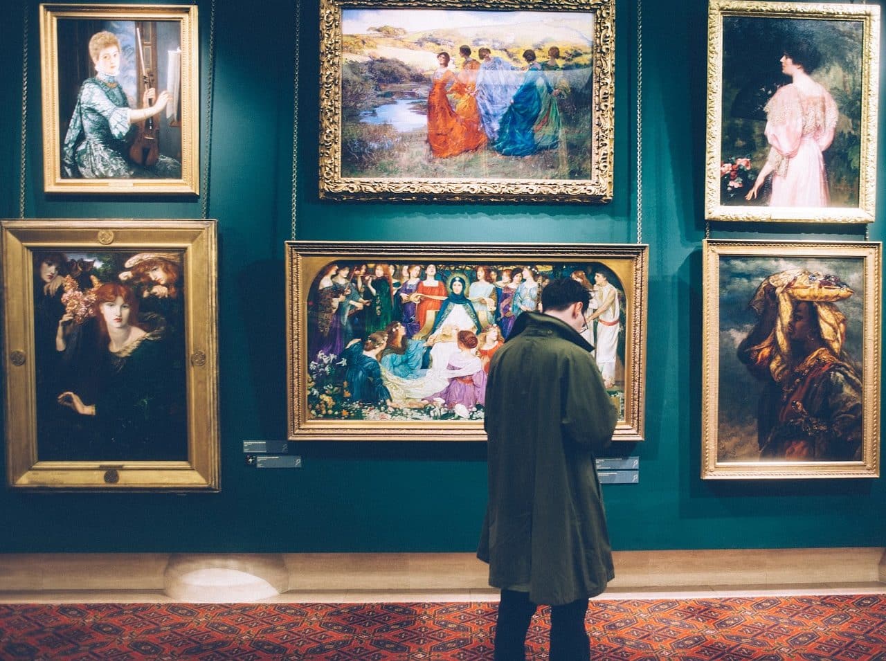 Man in museum, in front of paintings