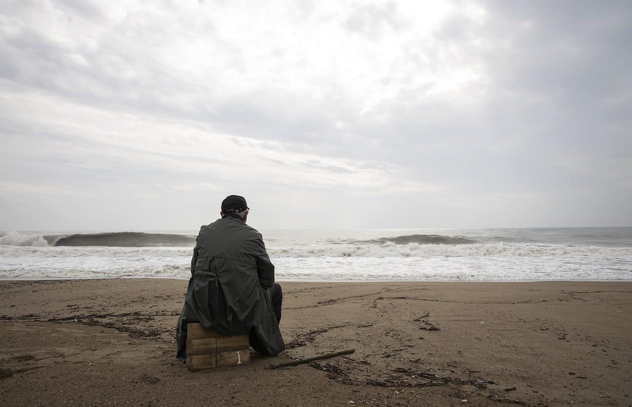 Listless man sitting in front of the sea