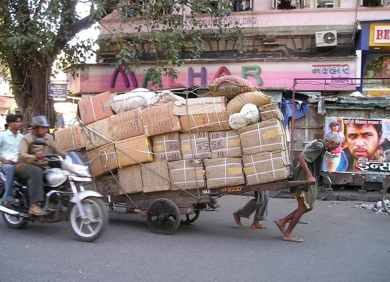 Man pulling a cart loaded with cardboard boxes