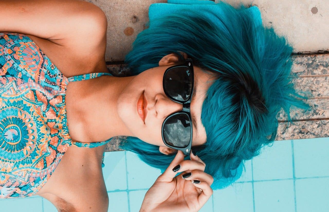 Young woman with blue hair and sunglasses