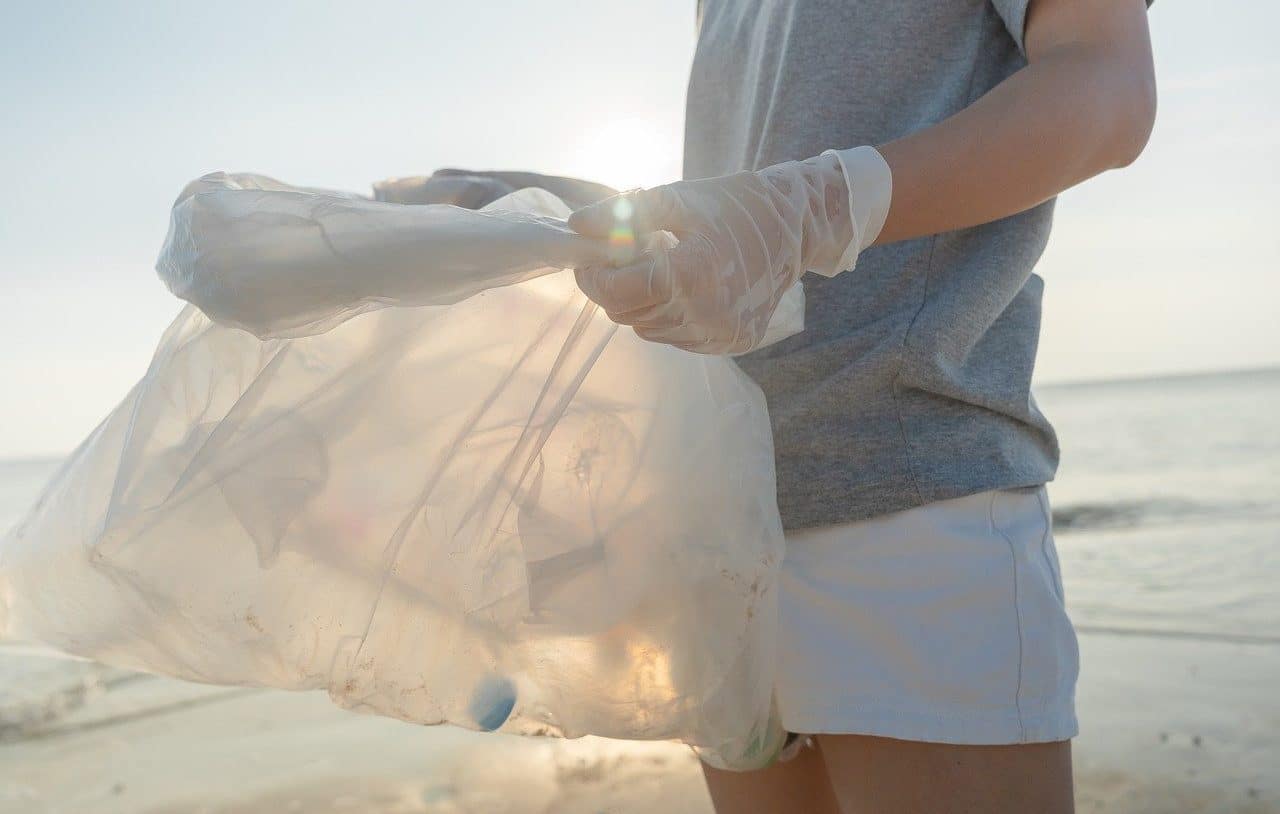 Woman collecting plastic on the beach