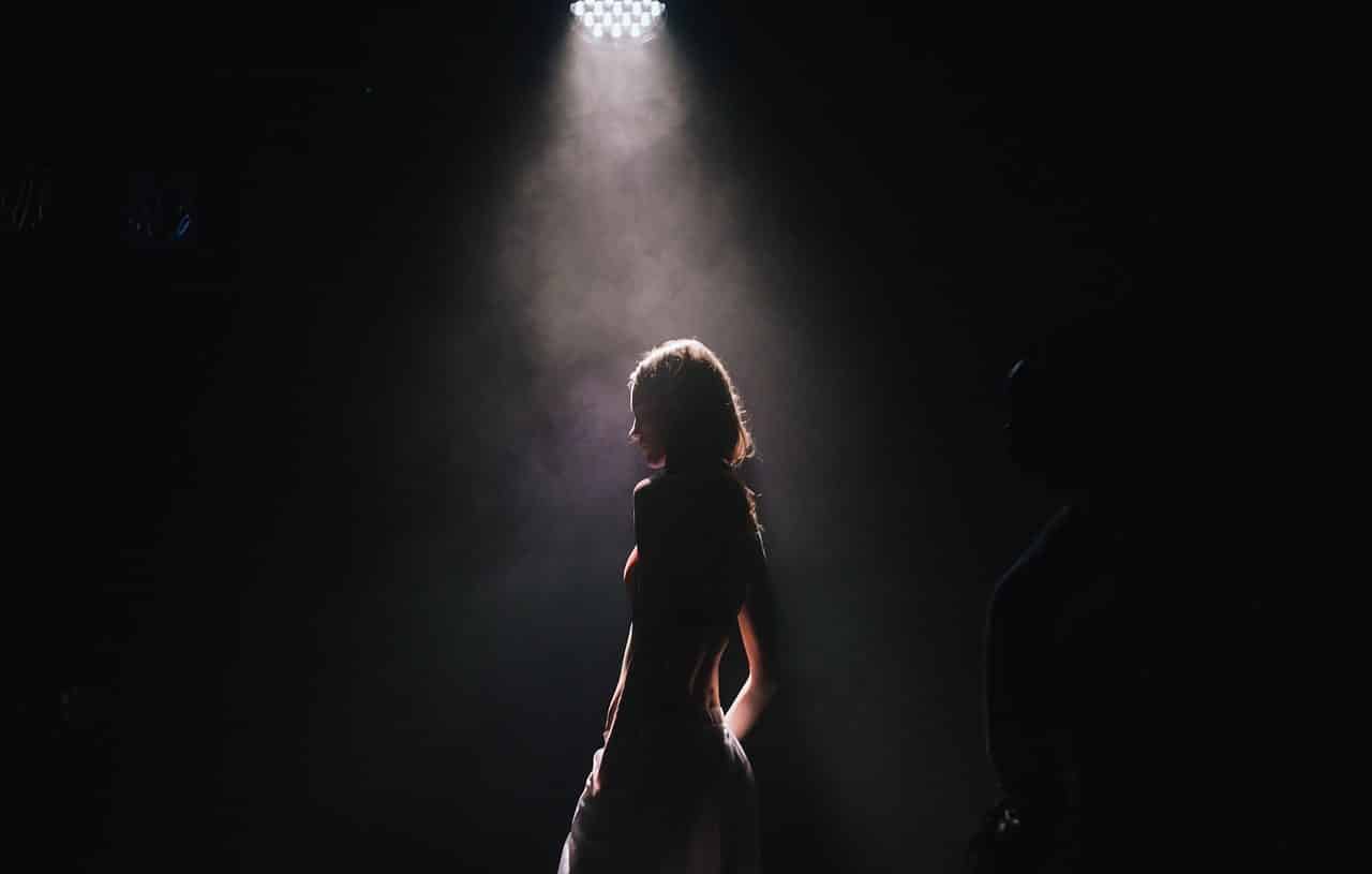 Woman illuminated by a spotlight in the dark