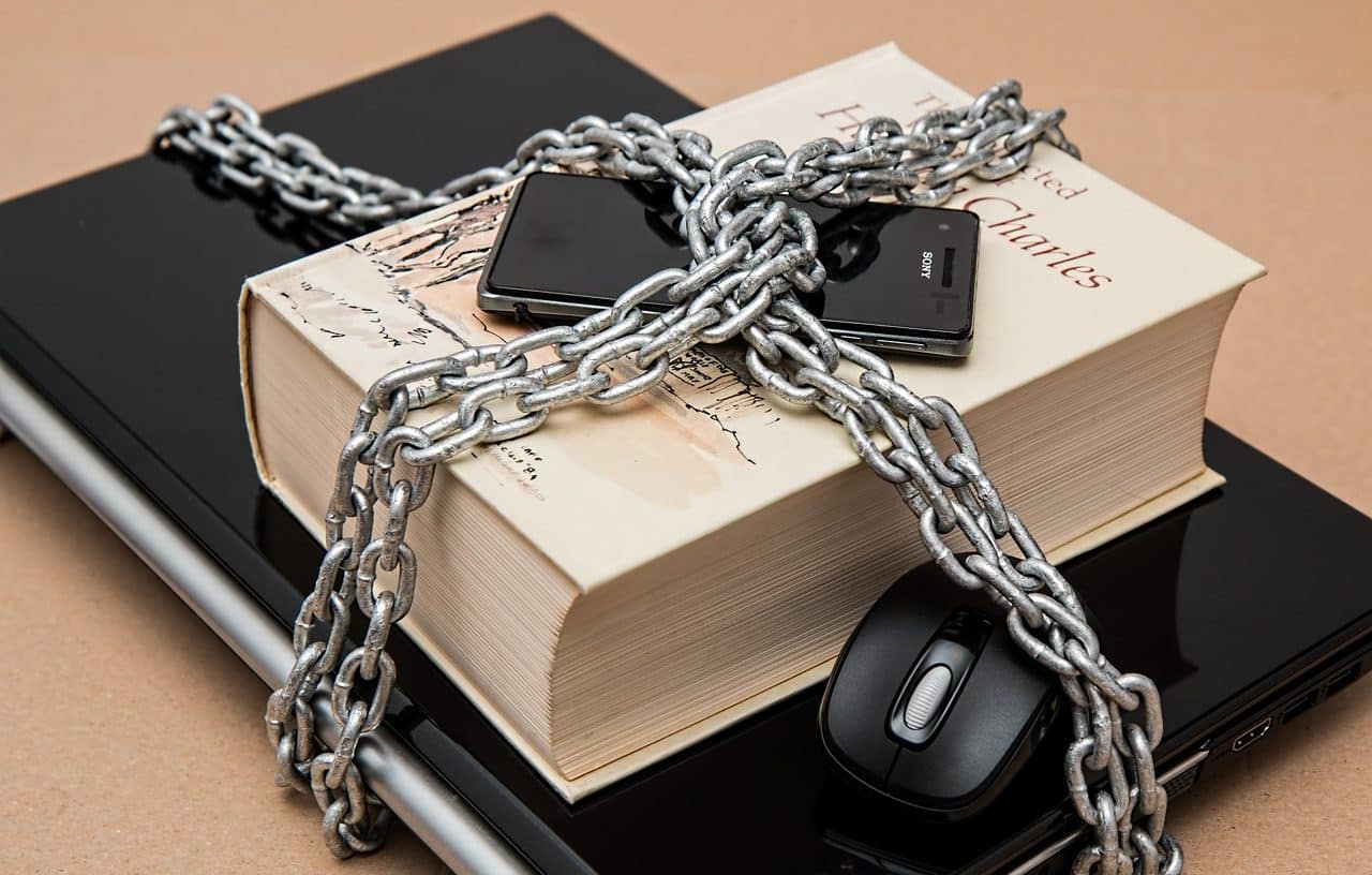 Chained laptop, book, cell phone and mouse