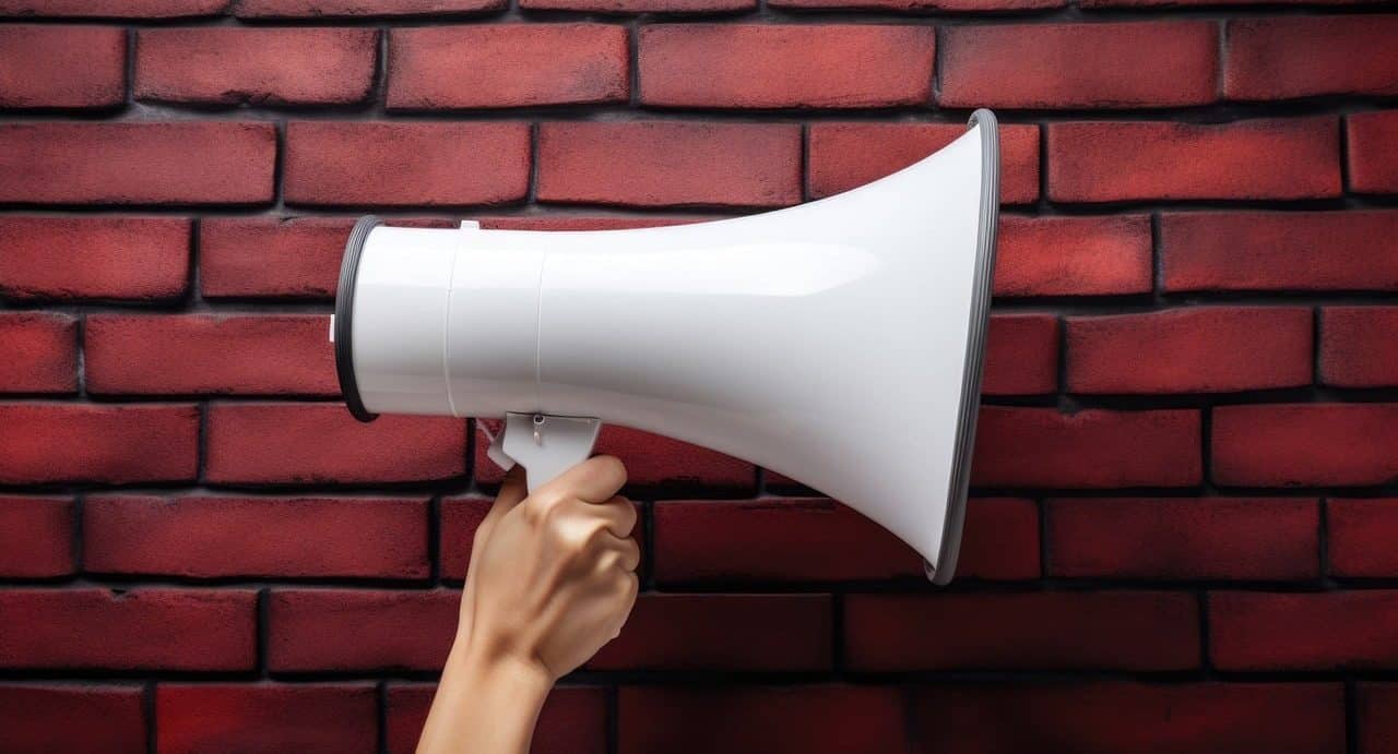 Person holding a megaphone on bricks background