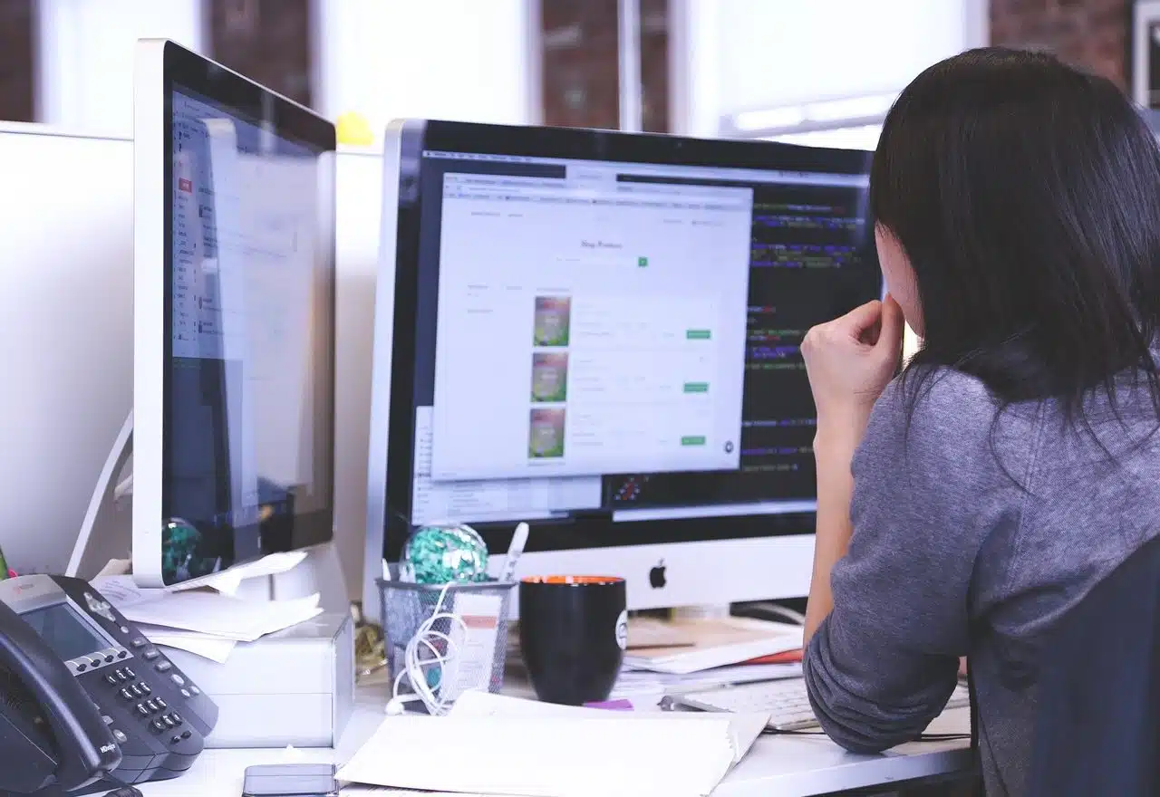 Woman working with her two-monitor computer