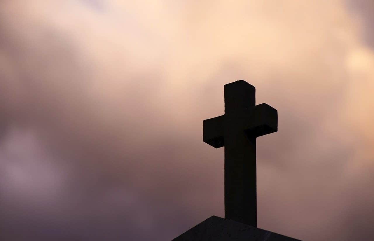 Cross nailed to the ground with the sky in the background