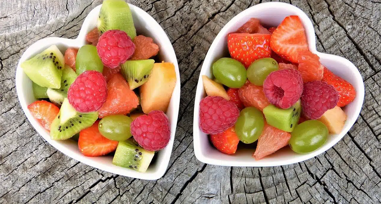 Two heart-shaped bowls filled with fruits