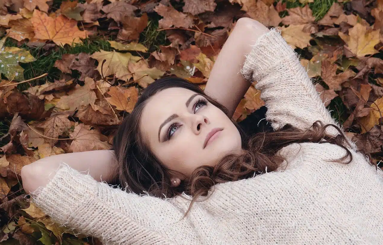 Young woman lying on dry leaves