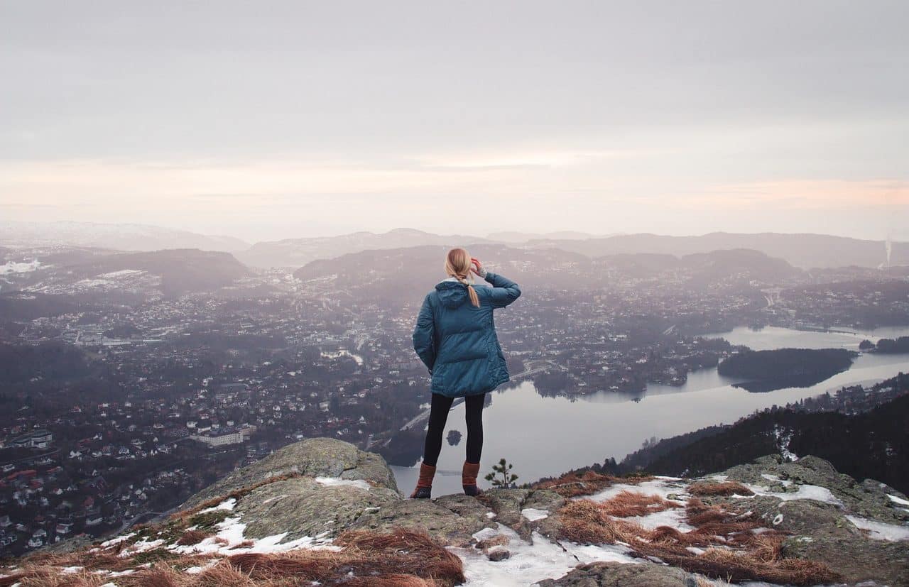 Woman at a viewpoint observing a town