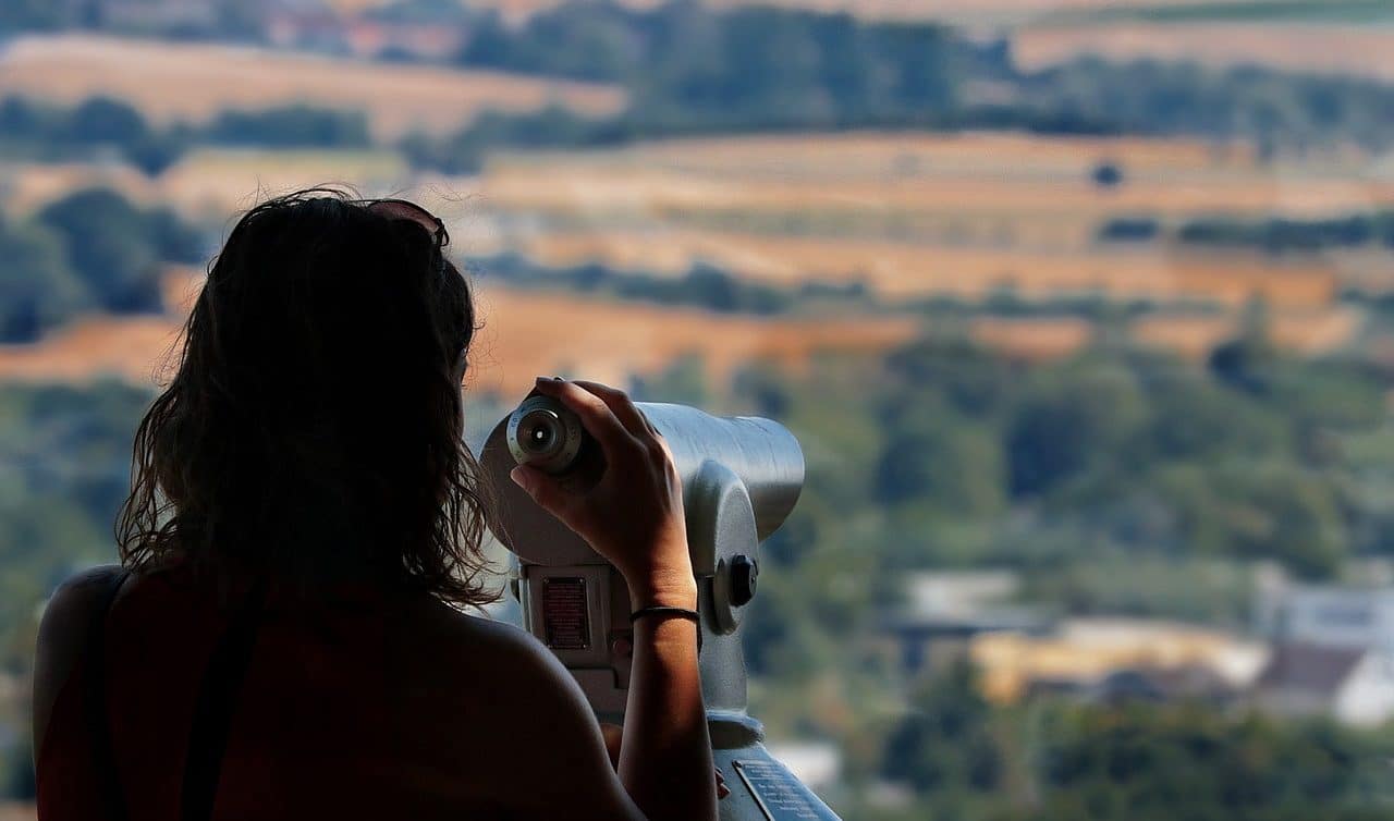 Woman using a telescope from a viewing point