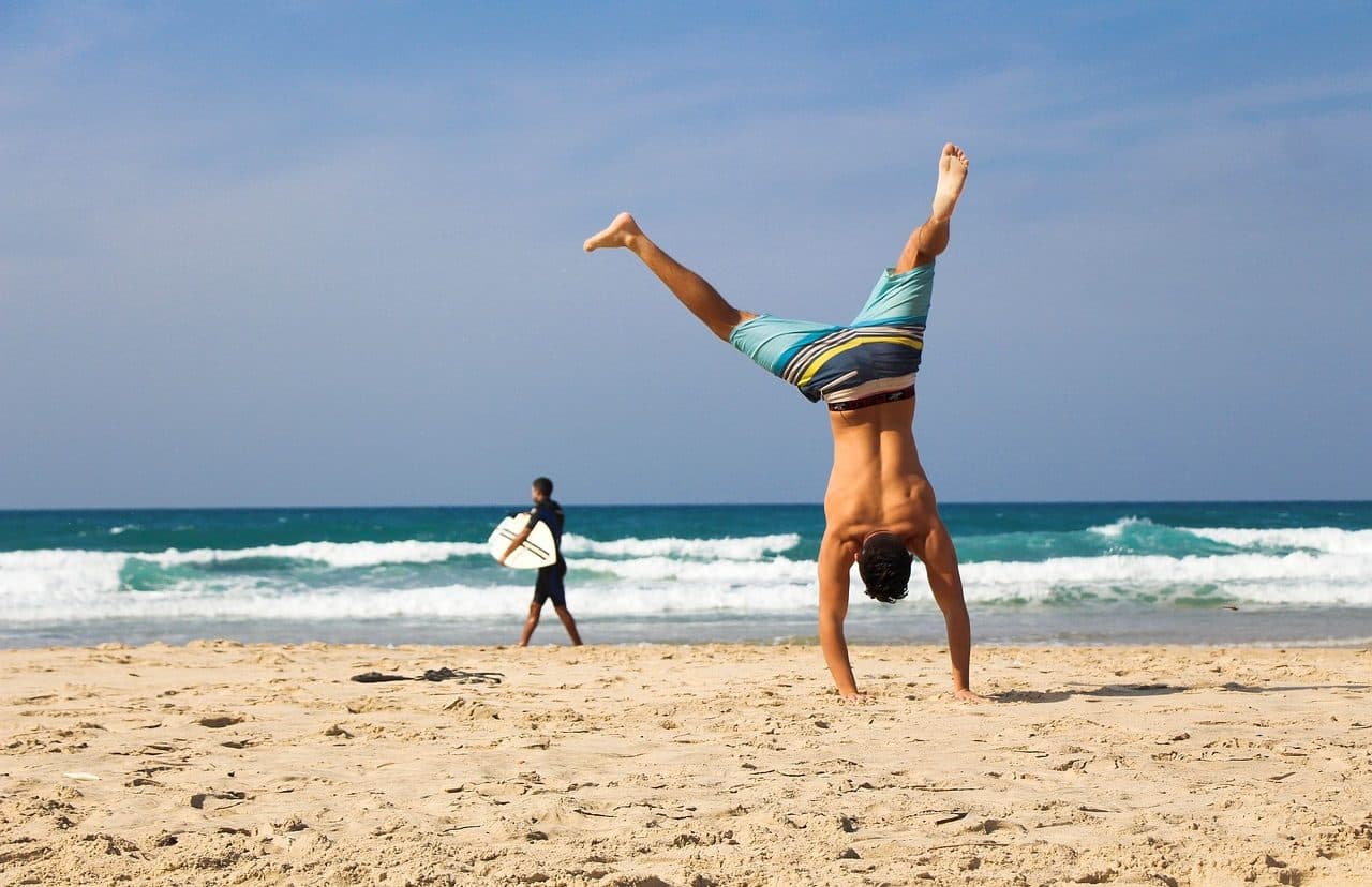 Man standing on his hands on the beach