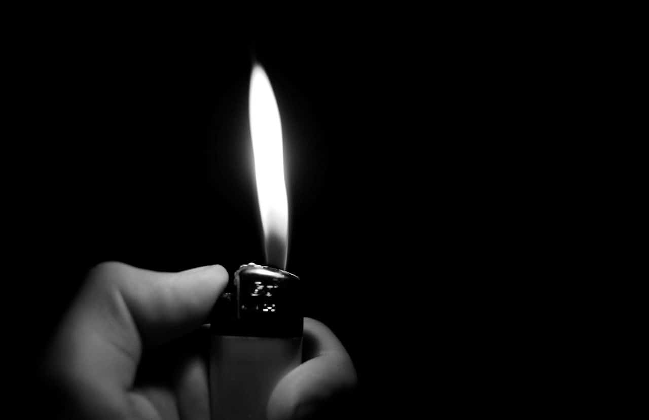 Hand holding a lighter in the dark