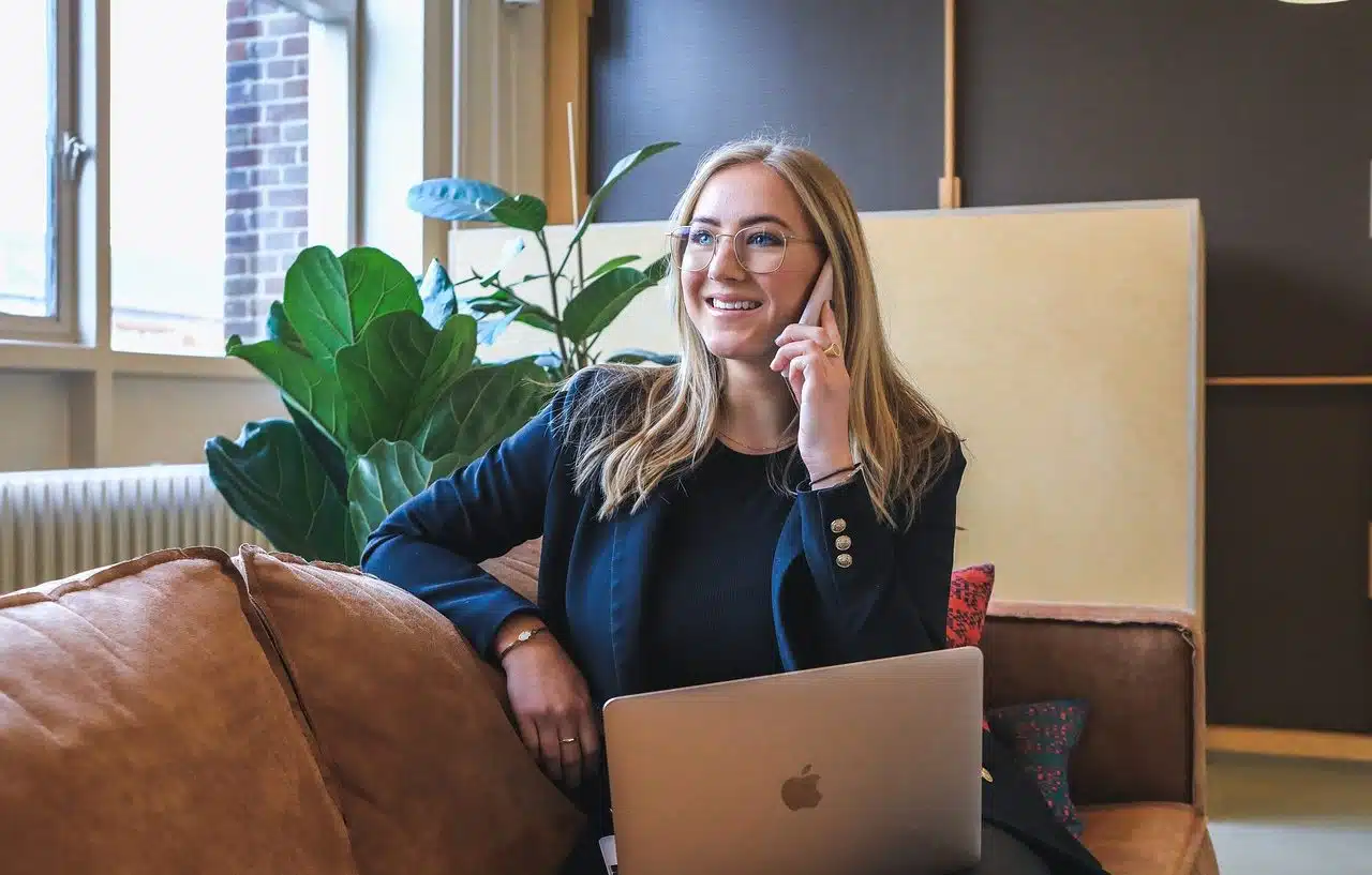 Businesswoman talking on the phone and using an Apple laptop