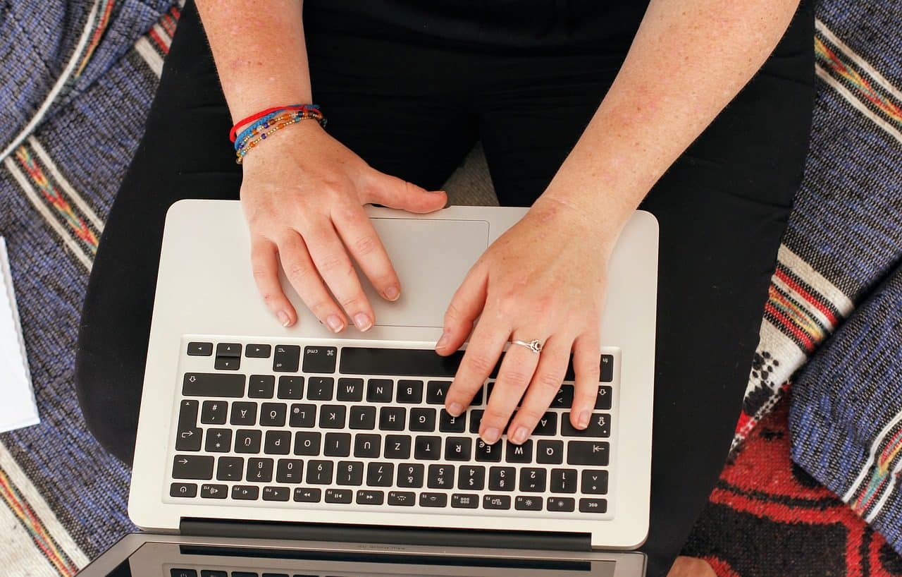 Person sitting on bed with laptop