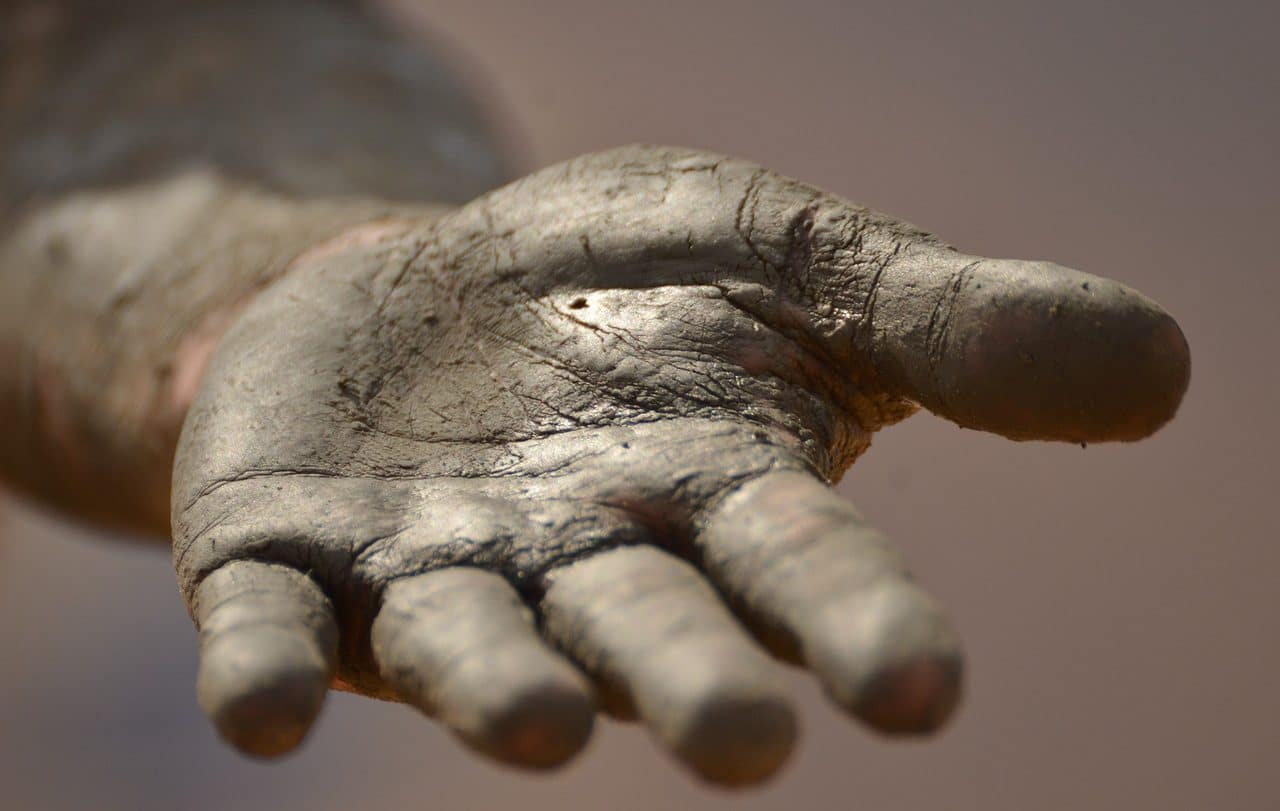 Mud covered hand extended