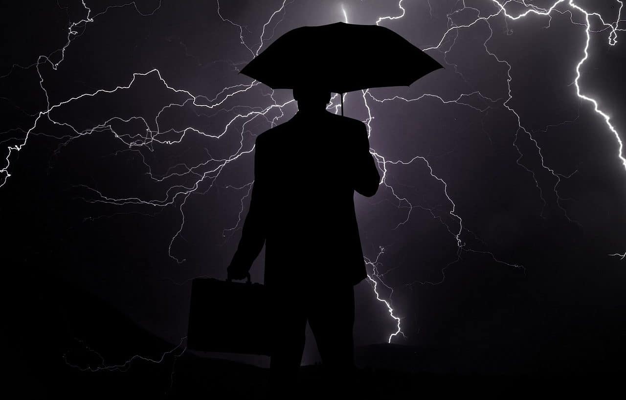 Man with umbrella under a thunderstorm