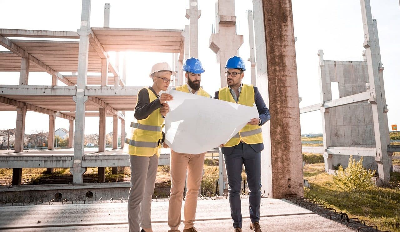 Three people working on a construction site