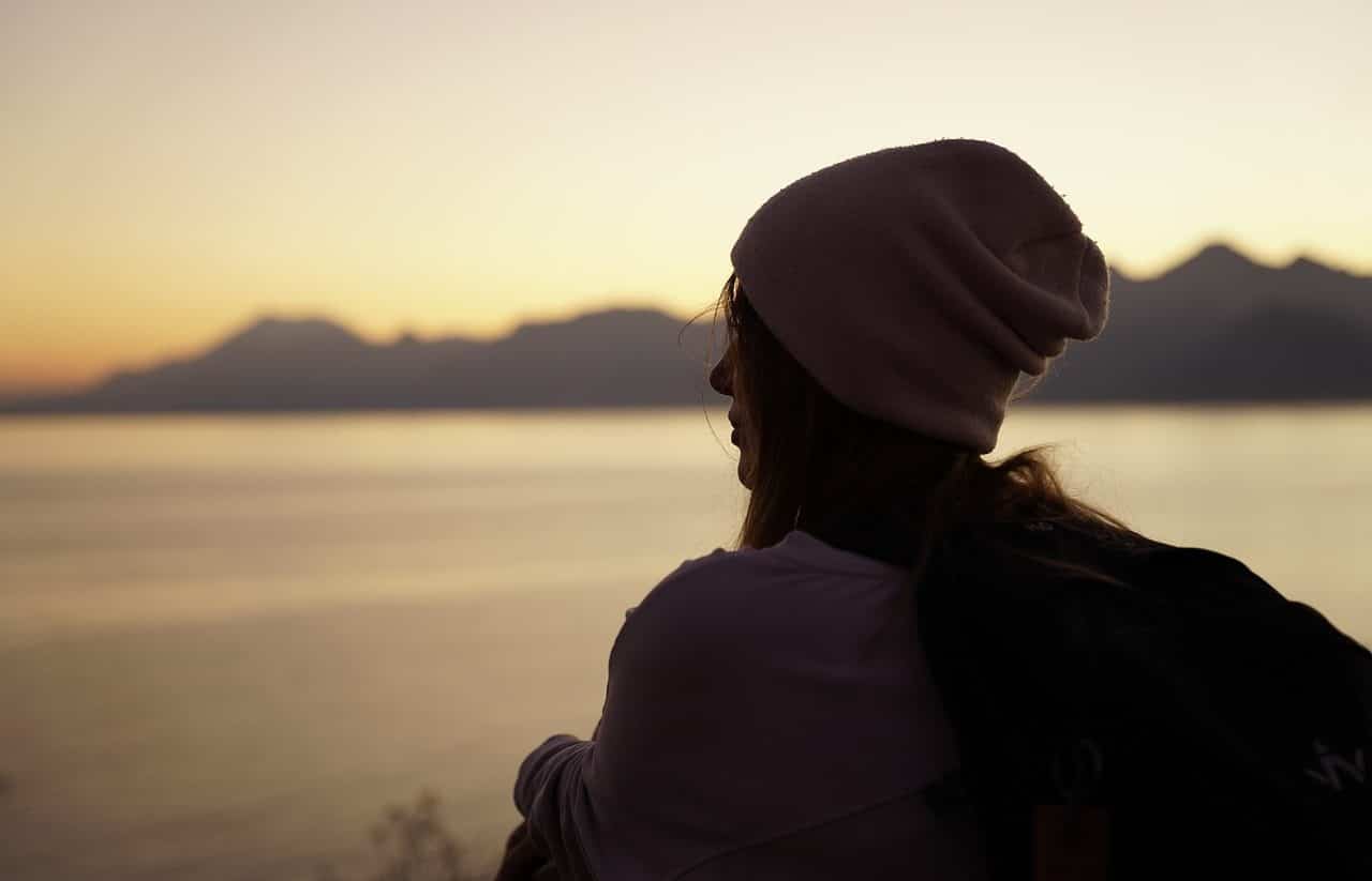 Young woman looking at the sea at sunset