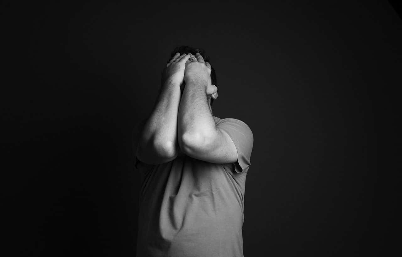 Man covering his face with his hands. Black and white photography