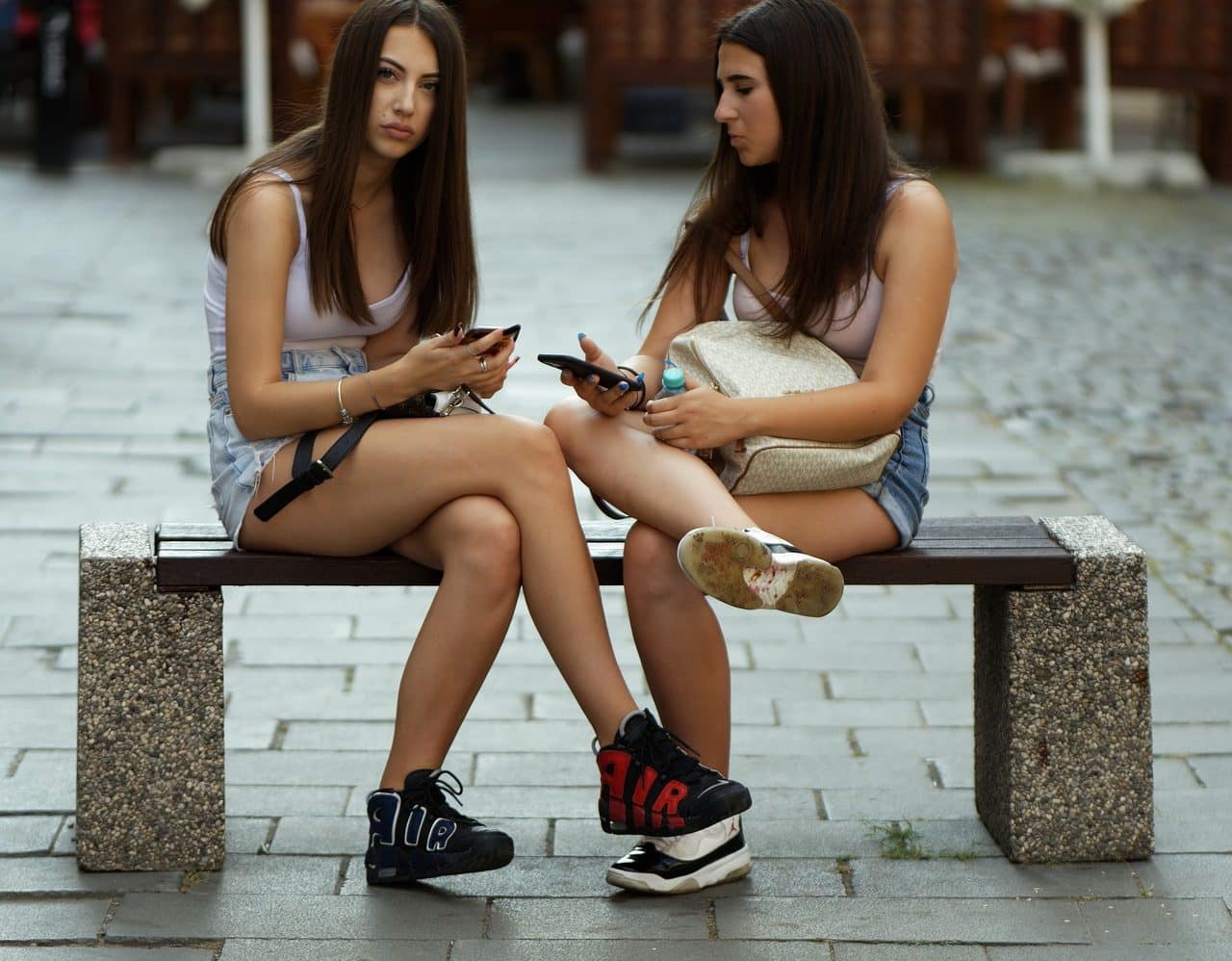 Two teenagers sitting on a park bench