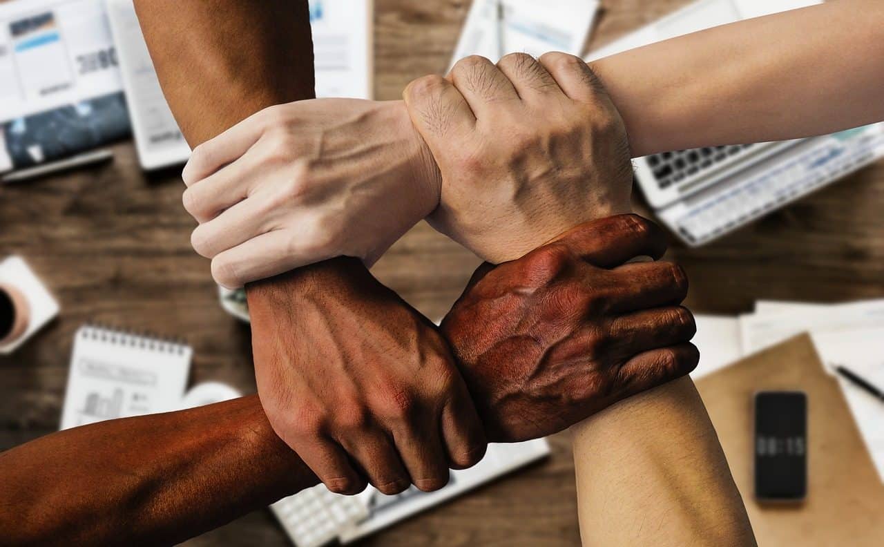 Four people of different races joining hands