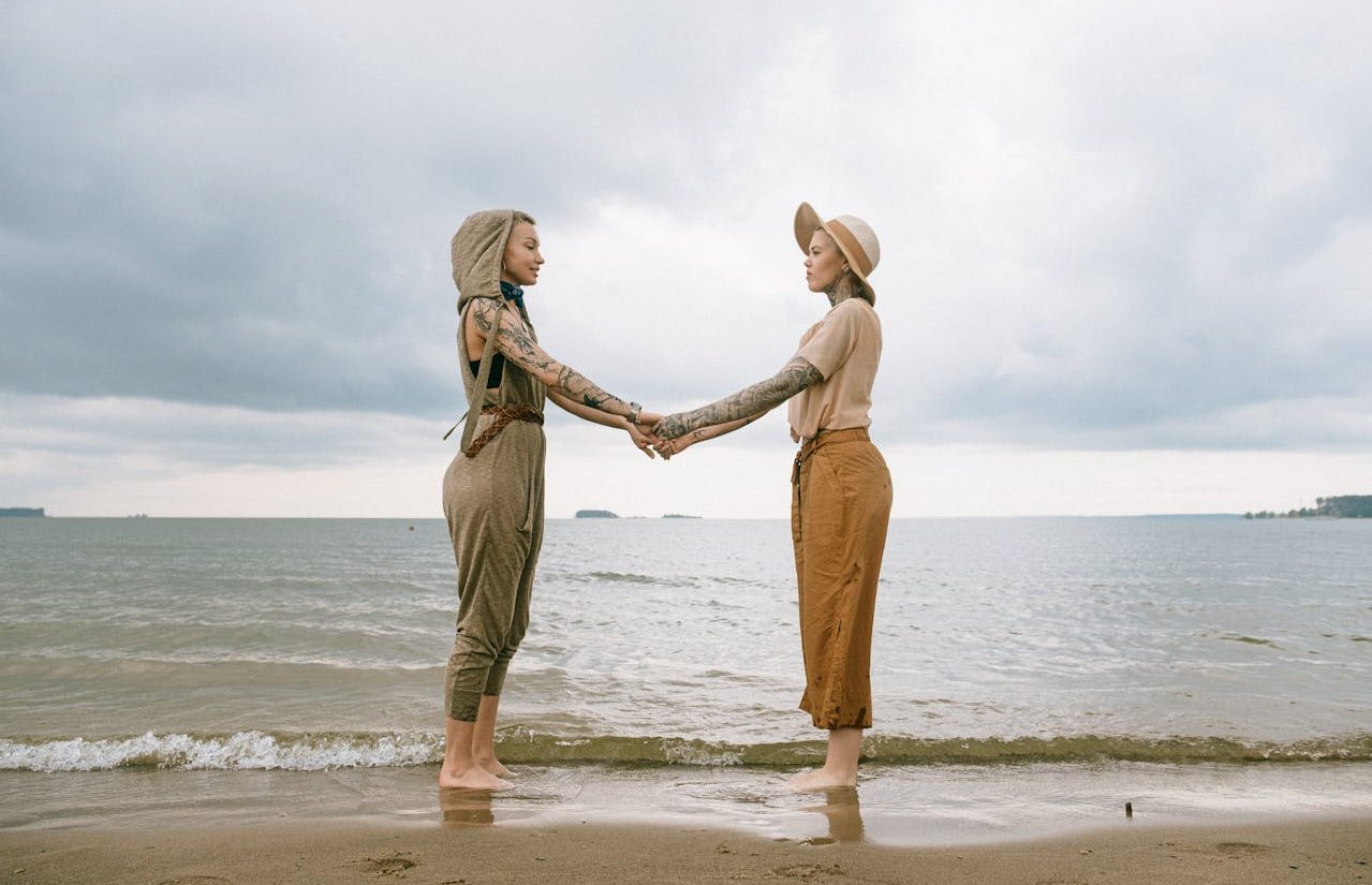 Two non-binary people on the beach