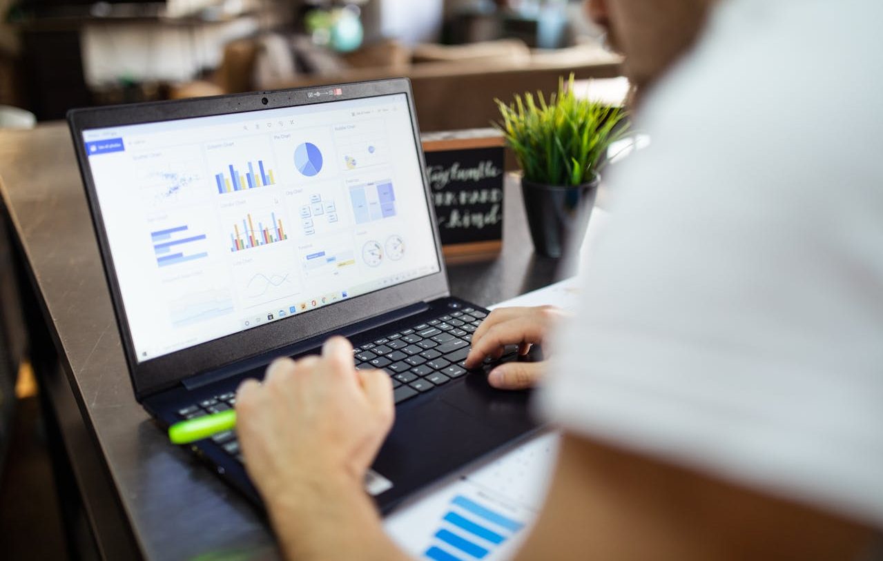 Person working on his computer with financial graphs