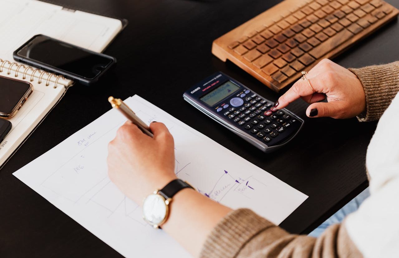 Person using scientific calculator and hand writing on a sheet