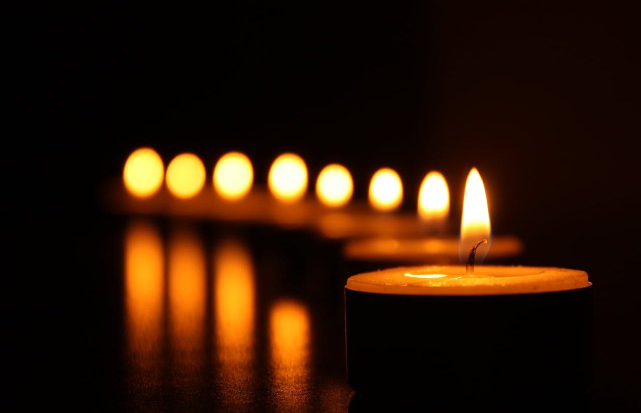 Row of lit candles in the dark